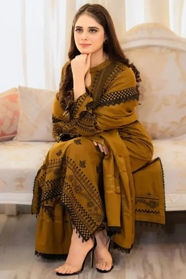 Woman in a mustard yellow traditional outfit sitting on a couch.