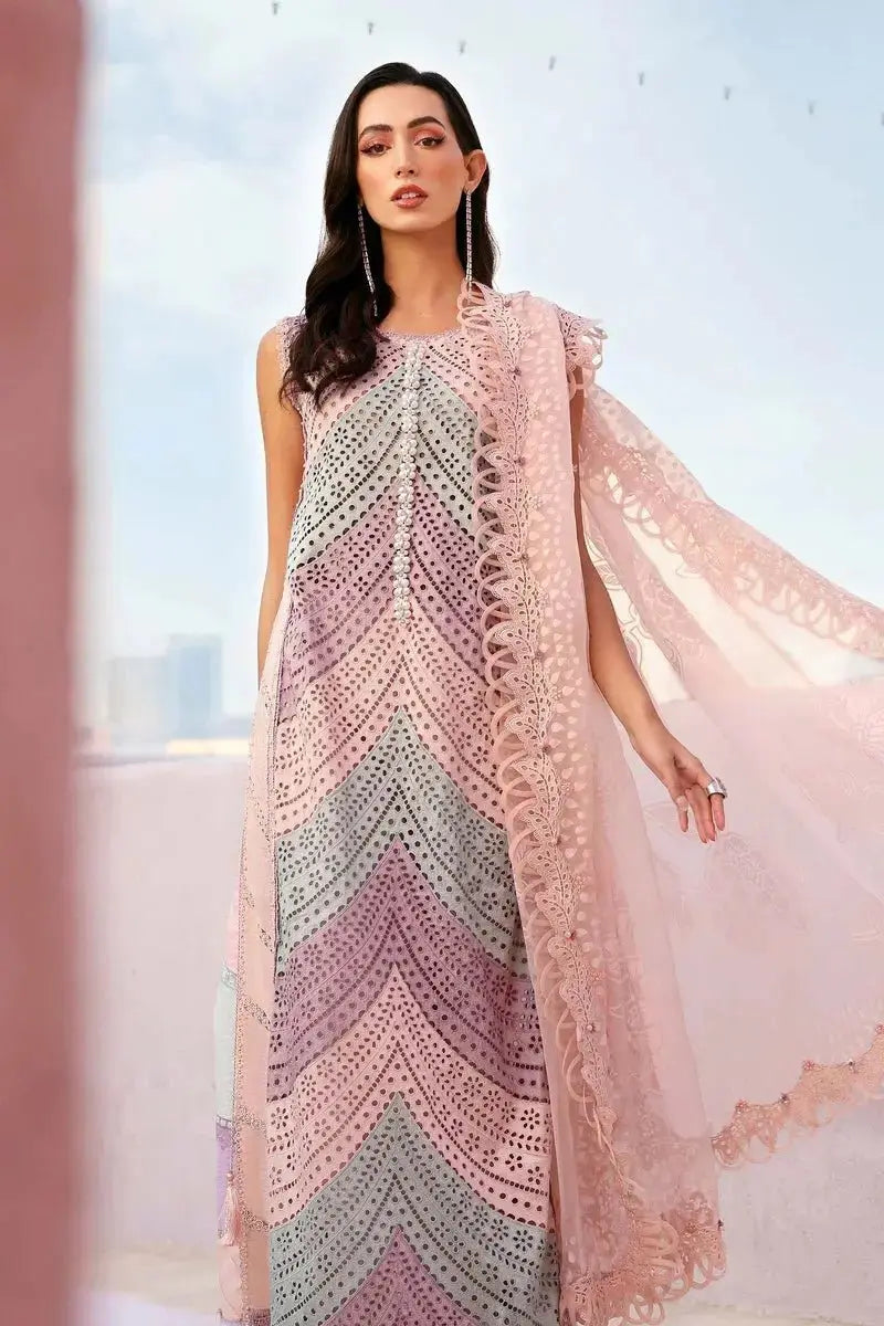Woman wearing a long, patterned dress with a flowing design against a light background