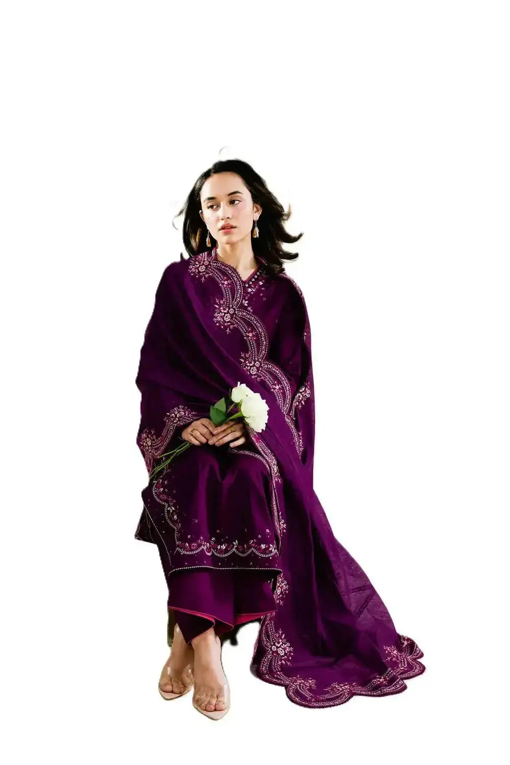 Woman wearing a purple embroidered traditional outfit holding a white flower on a white background