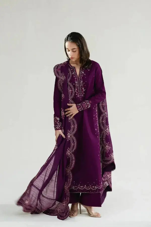 Woman wearing a purple embroidered traditional outfit on a white background